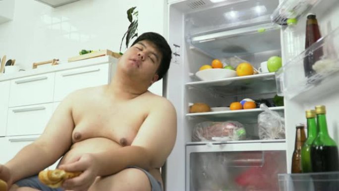 dolly低角度视图: 超重的泰国男子一直在冰箱里睡觉