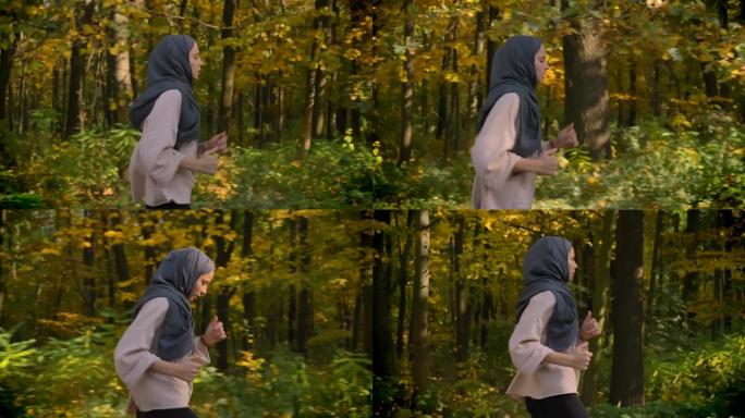 简介中的剪裁肖像，多莉拍摄了年轻的穆斯林女孩在秋森林中奔跑的头巾。