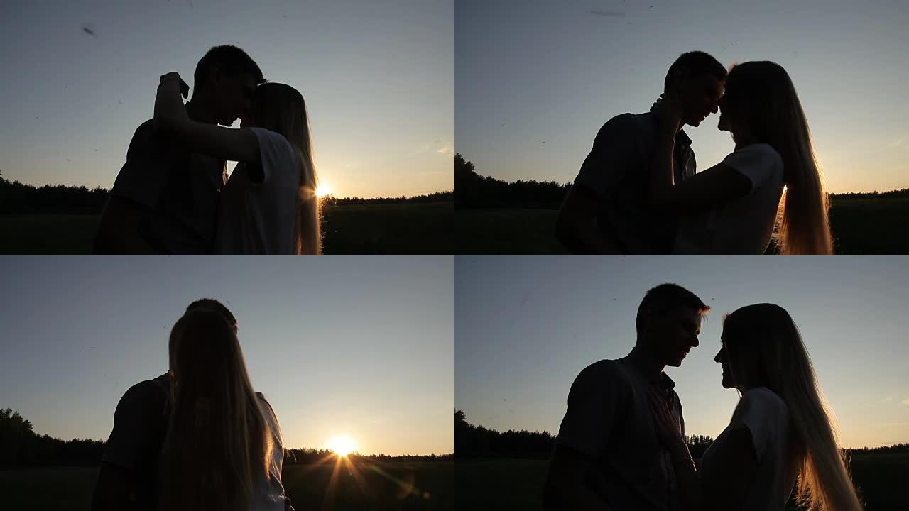 日落时分，男女生在田野里接吻和拥抱