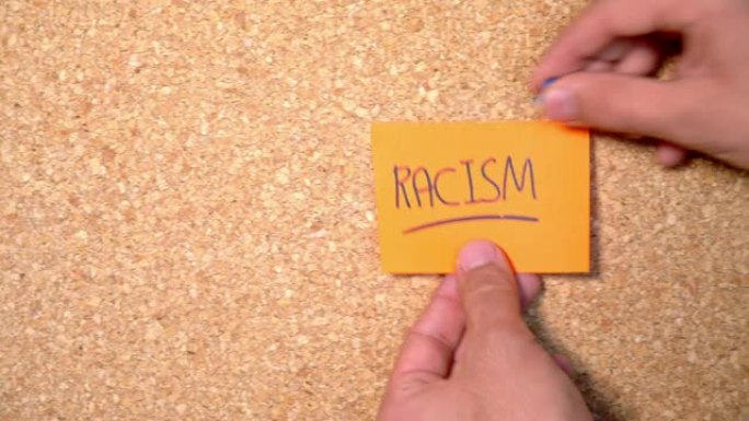 一个男人把种族主义的文字贴在木板上