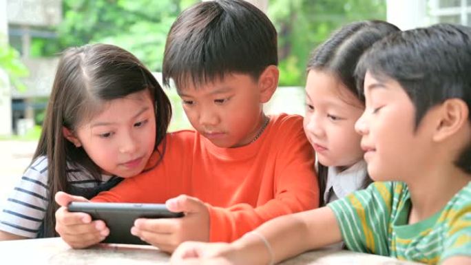 一大群年轻男孩和女孩共享平板电脑和智能手机技术