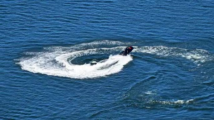男子在蓝色海水上骑着喷气滑雪踏板车