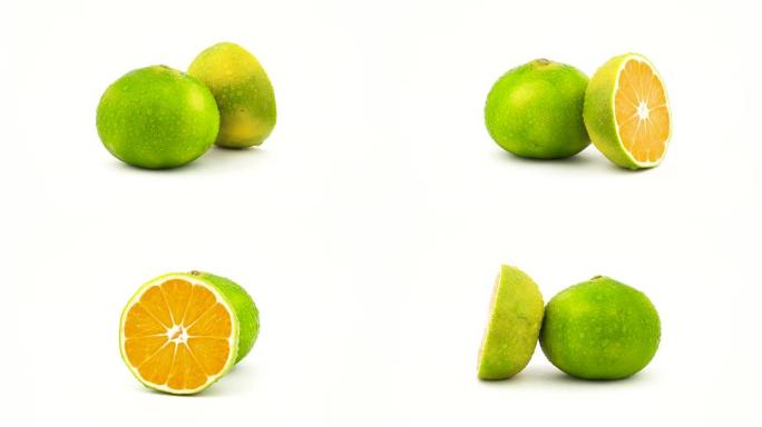 用水滴将绿色橘子果实切成一个整体和一半。在转盘上旋转。孤立在白色背景上。特写。宏观。