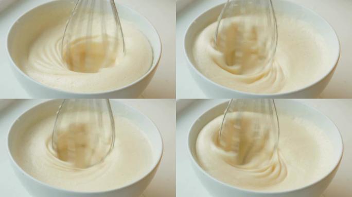 在白碗中搅拌搅打的蛋白和糖