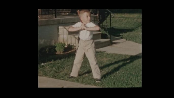 1956可爱的小男孩，棒球棒在球场上挥杆