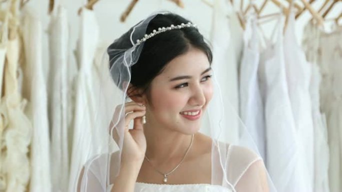 亚洲女性美丽的新娘把她的珠宝和结婚耳环