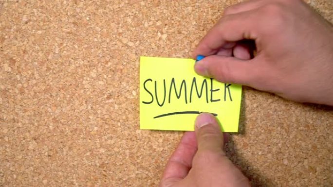 一个男人钉在软木板上的纸上夏天的文字