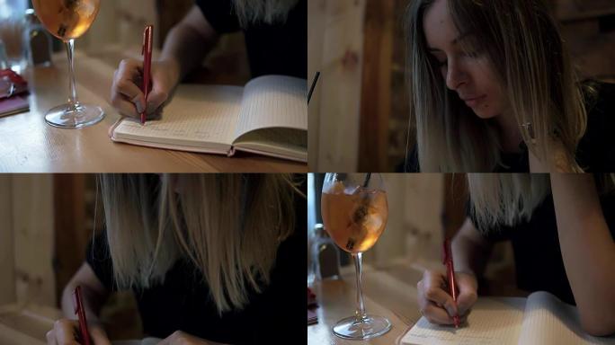 长发金发女子坐在现代咖啡馆里，若有所思地在笔记本上做笔记。桌上一杯加冰的鸡尾酒。笔记本的目标镜头