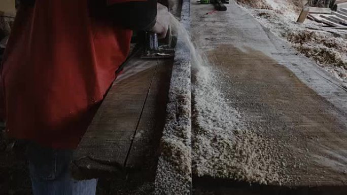 SLO MO: 一个木匠正在工厂切割一块大木板。