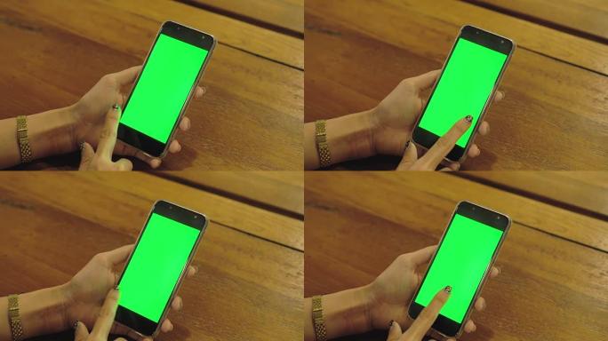 女人手持智能手机，屏幕上有空白的绿色屏幕触摸和滑动。