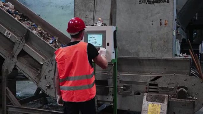 废物处理场的工人在触摸屏上控制传送带速度