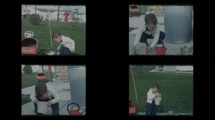 1961可爱的小男孩玩花园软管水和水桶