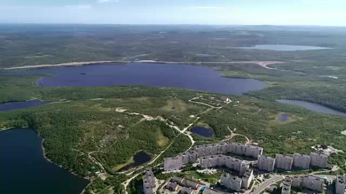 摩尔曼斯克苏维埃建筑的城市景观和夏季的明亮树叶