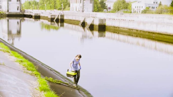 生态学家在城市河流中获取水样本