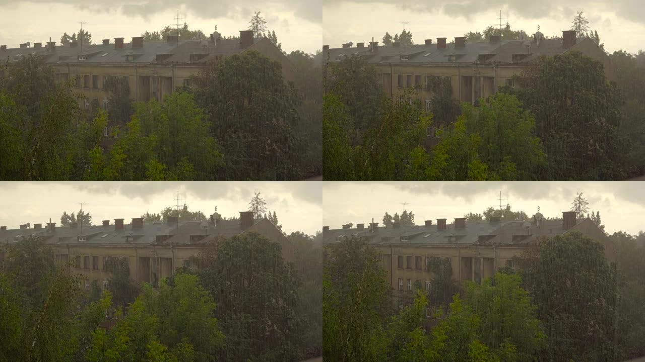 雨滴落在建筑物及其屋顶和树木的背景上。水滴从灰色，多云的天空掉入一栋大型住宅建筑的庭院