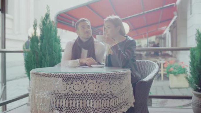 恋爱中的情侣在户外咖啡馆浪漫约会时喝咖啡