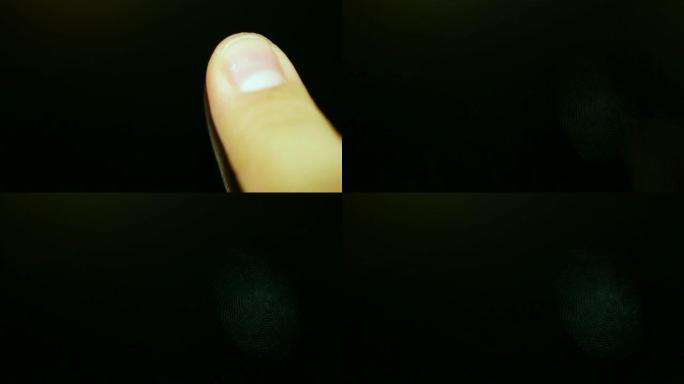 一个人将手指放在黑色表面上并在其上留下指纹的镜头