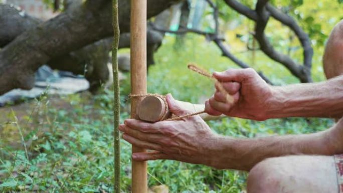 一个高加索人使用竹木在花园里建造天然篱笆