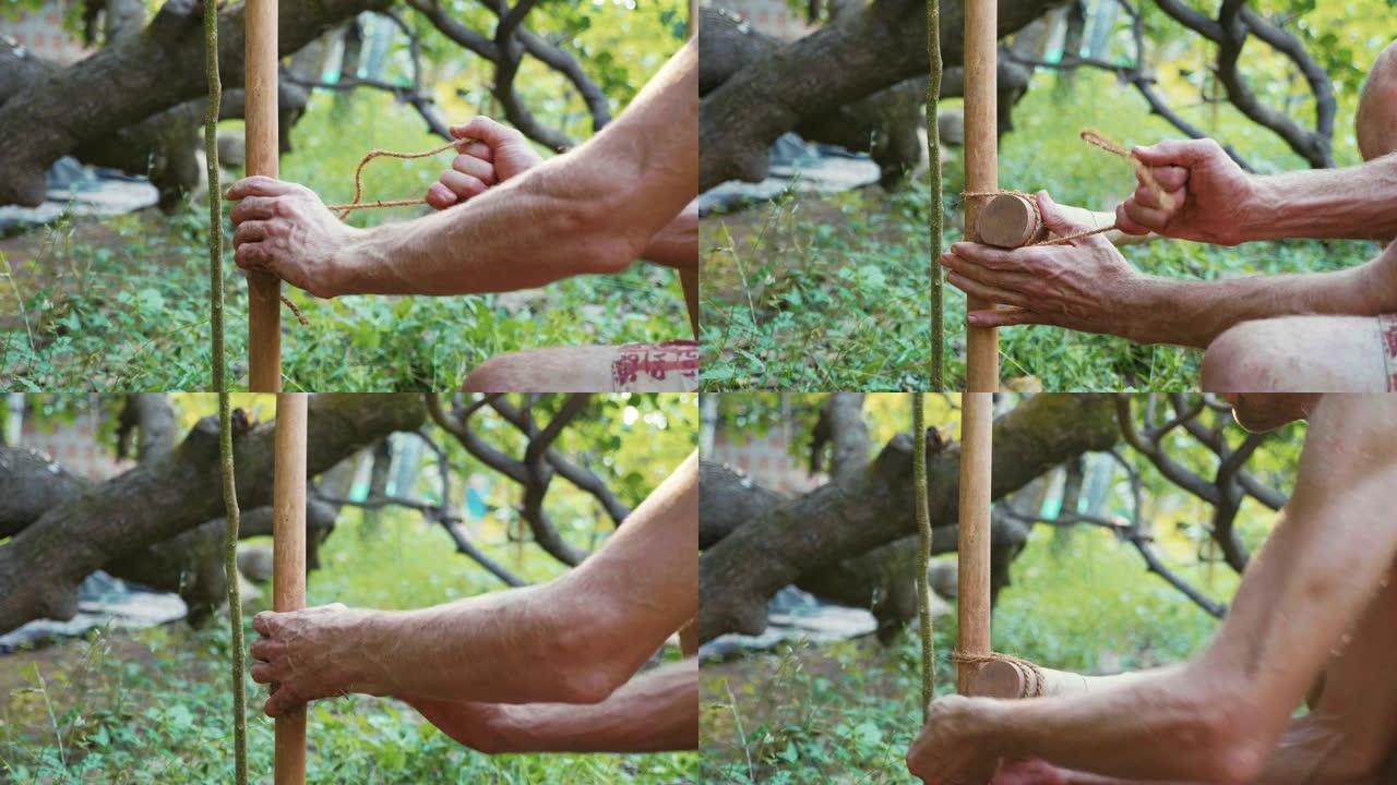 一个高加索人使用竹木在花园里建造天然篱笆