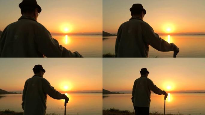快乐时光，资深亚洲男性欣赏湖边日落，慢动作