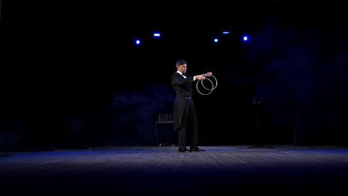 魔术师在舞台上操纵铁箍