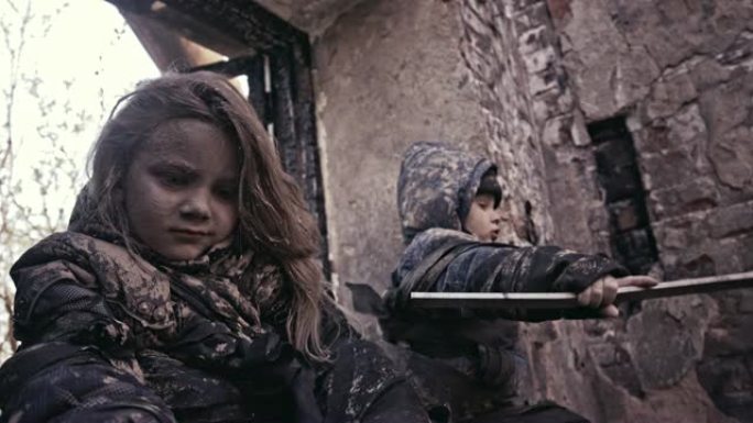 废墟附近饥饿的无家可归的孩子。难民