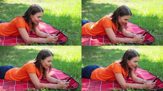 可爱的年轻女子躺在草地上使用手机-视频高清