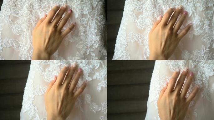 收起新娘的手温柔触摸美丽的婚纱。