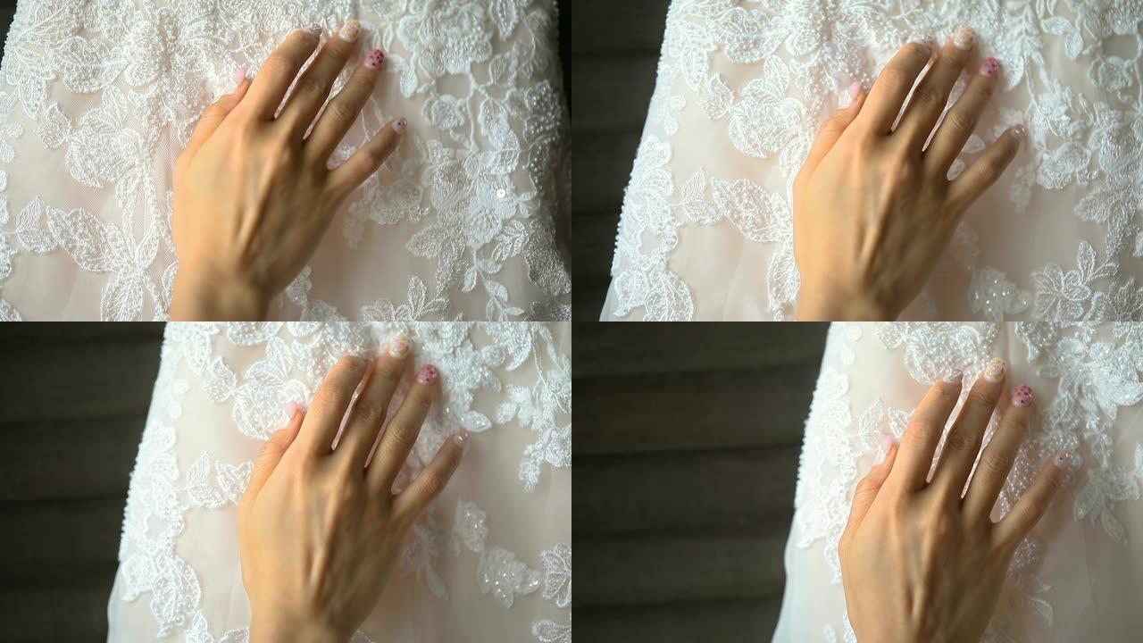 收起新娘的手温柔触摸美丽的婚纱。