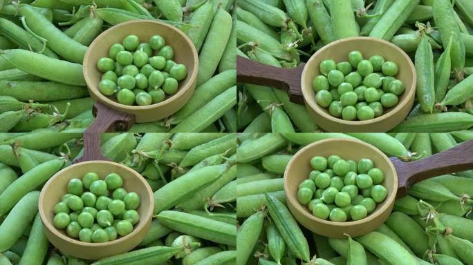 旋转绿色的豌豆荚和勺子中的豌豆