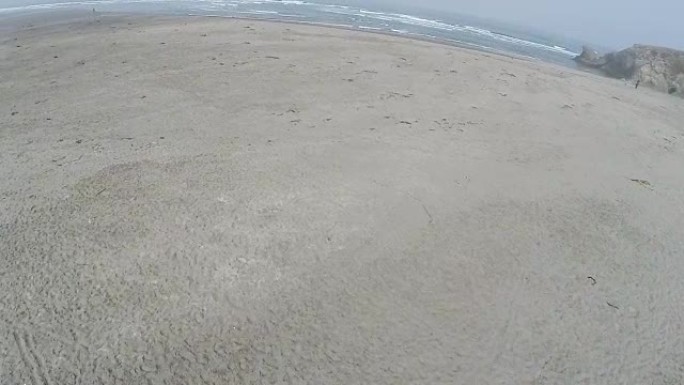 无人机在沙滩上飞向海洋