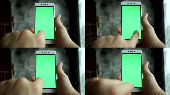 特写镜头手握和触摸绿屏垂直手机
