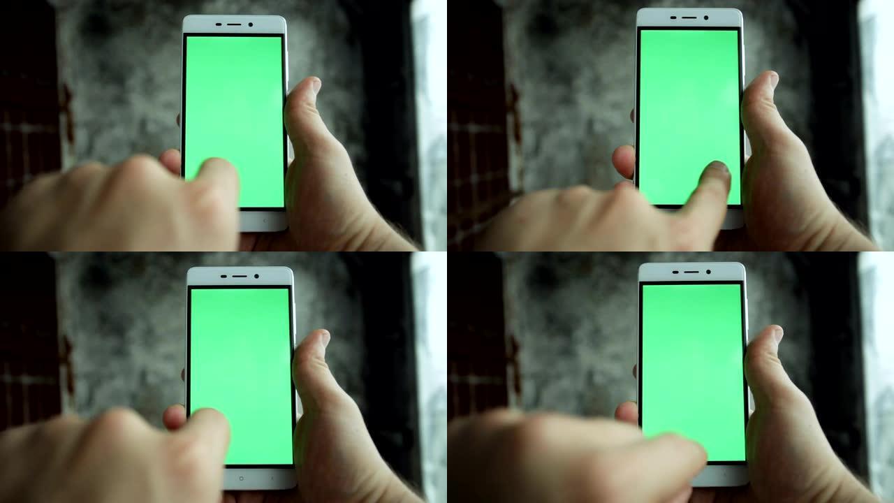 特写镜头手握和触摸绿屏垂直手机