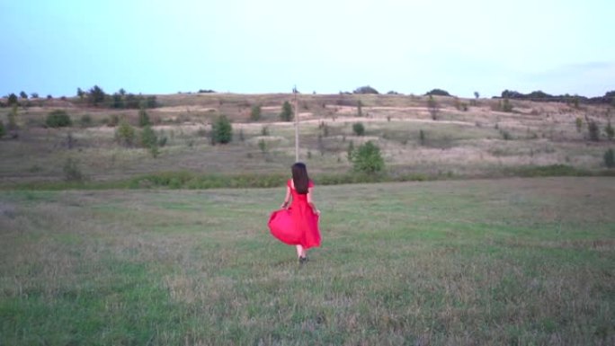 一位穿着红色连衣裙在野外奔跑的美丽女士