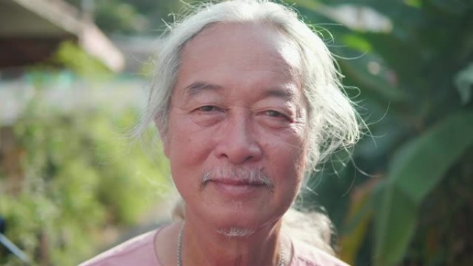 60年代男子肖像，亚洲高级男子微笑。老年人看着相机。