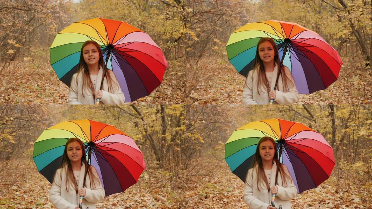 一个女孩带着雨伞在秋天的森林里散步