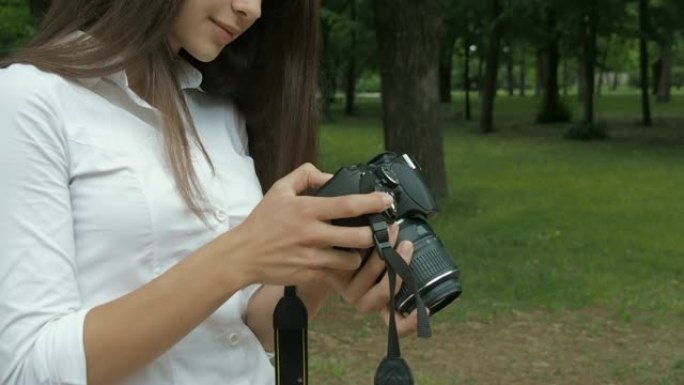 女孩透过相机里的照片看。