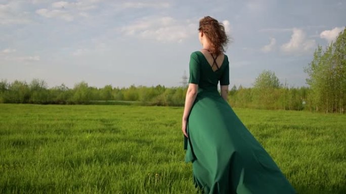 日落时分，年轻漂亮的女人穿着漂亮的衣服站在田野里