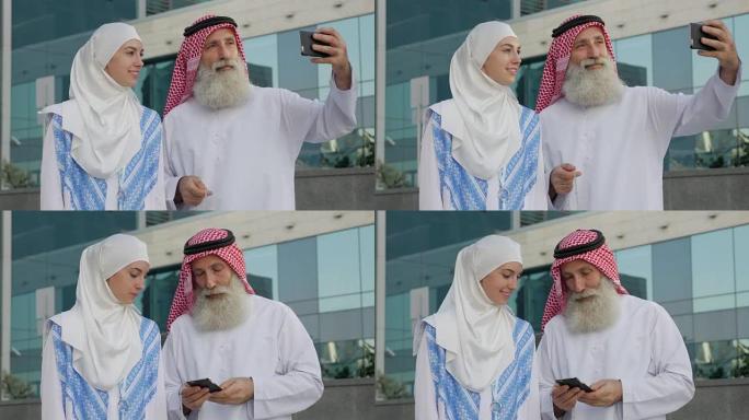 一个留着胡子的阿拉伯老年男子和一个年轻女孩在城市里用智能手机自拍