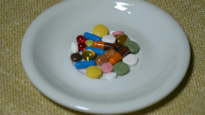 药丸。药物特写。带有棕橙色胶囊的水泡慢慢落在餐巾上。生物活性添加剂和维生素。特写。慢动作。