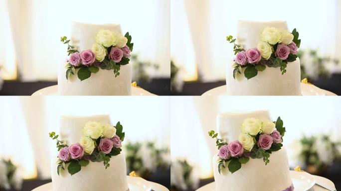 美丽的婚礼蛋糕装饰着鲜花和白色和紫色的色调。