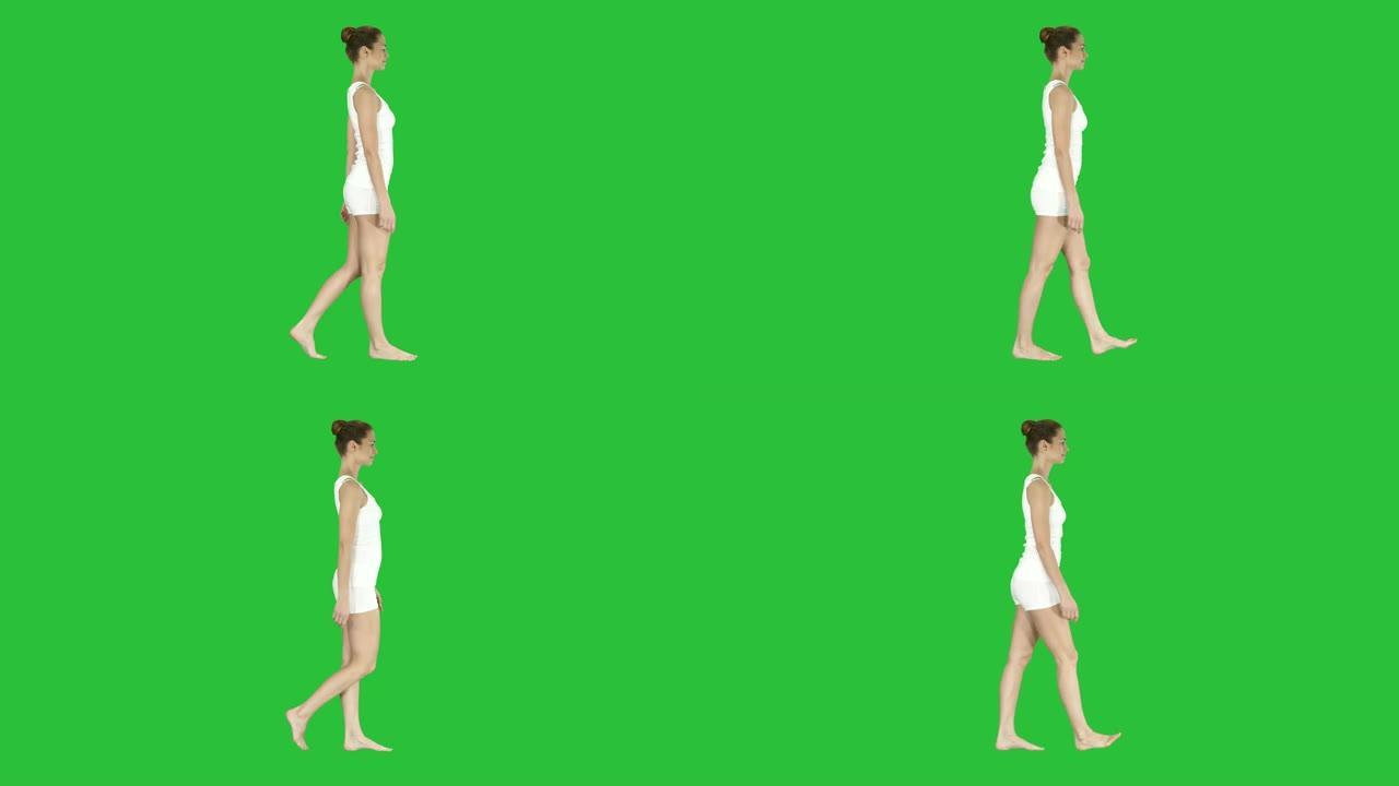 一名女性赤脚穿着白色衣服在绿色屏幕上行走，色键