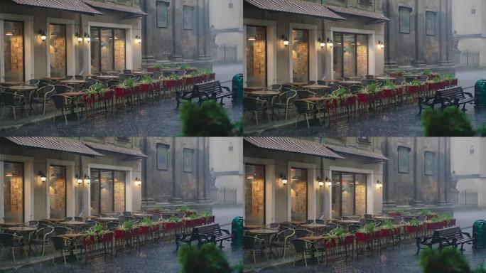 雨滴正落在街上餐厅的桌椅上。