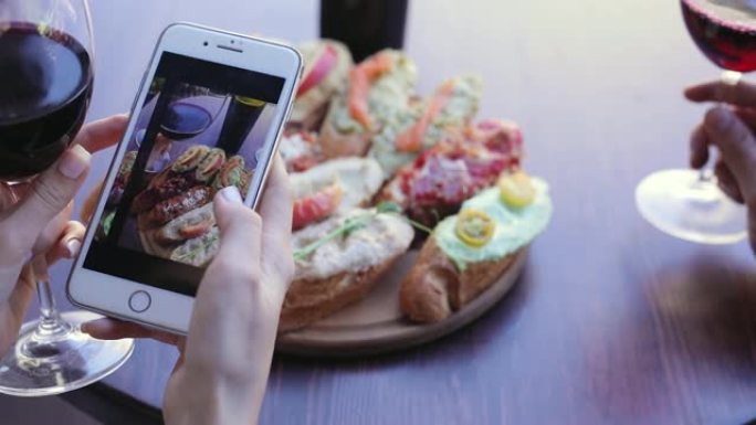 食物和饮料照片。女人看着手机屏幕上的图片