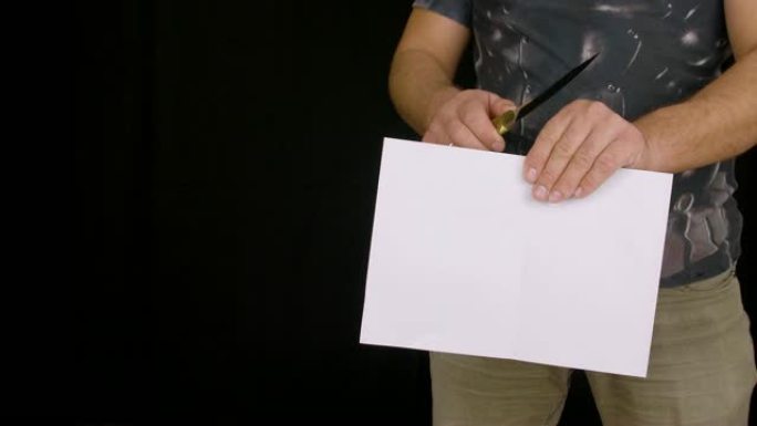 男性手持刀和测试黑色背景纸上的锋利刀片