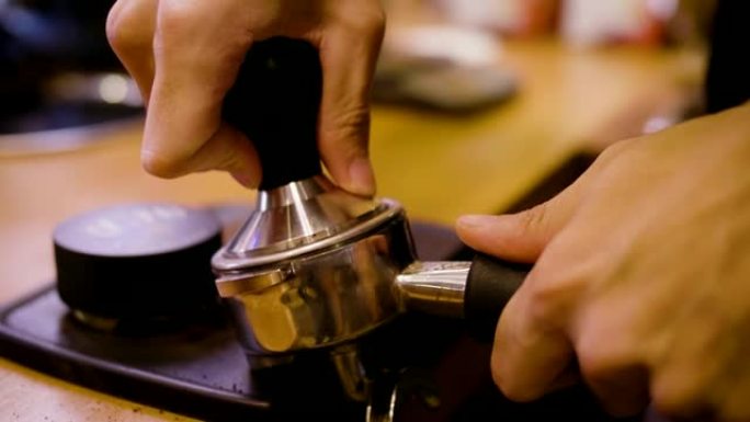 咖啡师在咖啡店用篡改压缩portafilter咖啡渣并制作咖啡浓缩咖啡