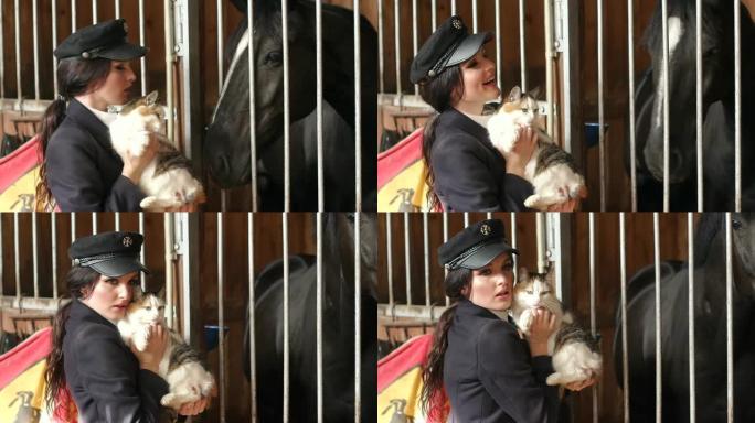 这个迷人的女孩在一匹黑马旁边的马stable里抱着一只猫。
