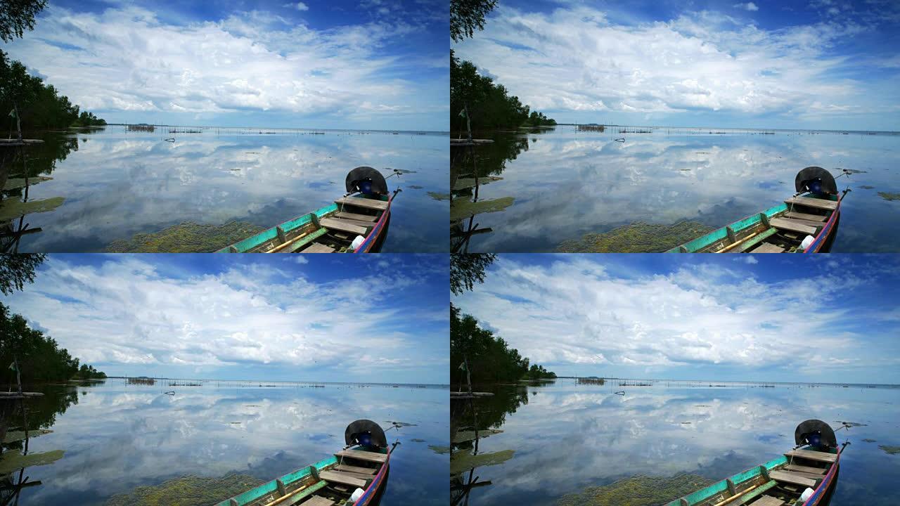 渔船停车时，在海上的蓝天上传递云彩，并在水中反射。