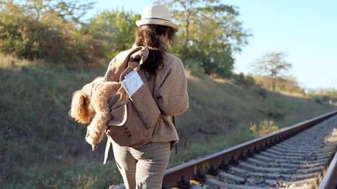 背着狗的女人乘铁路秋日旅行。