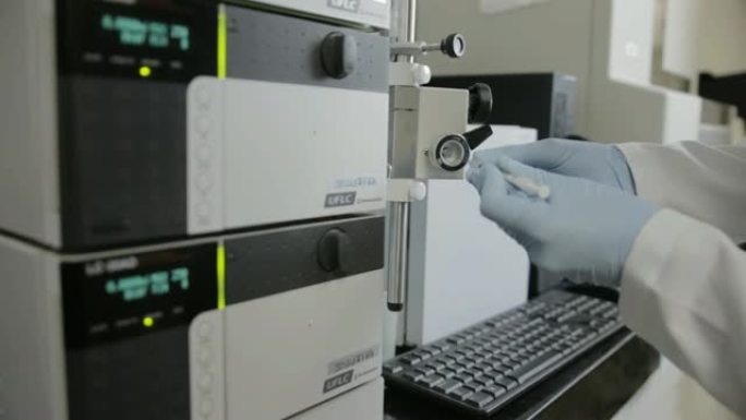 一名研究人员在大学遗传实验室检查HPLC的手持照片